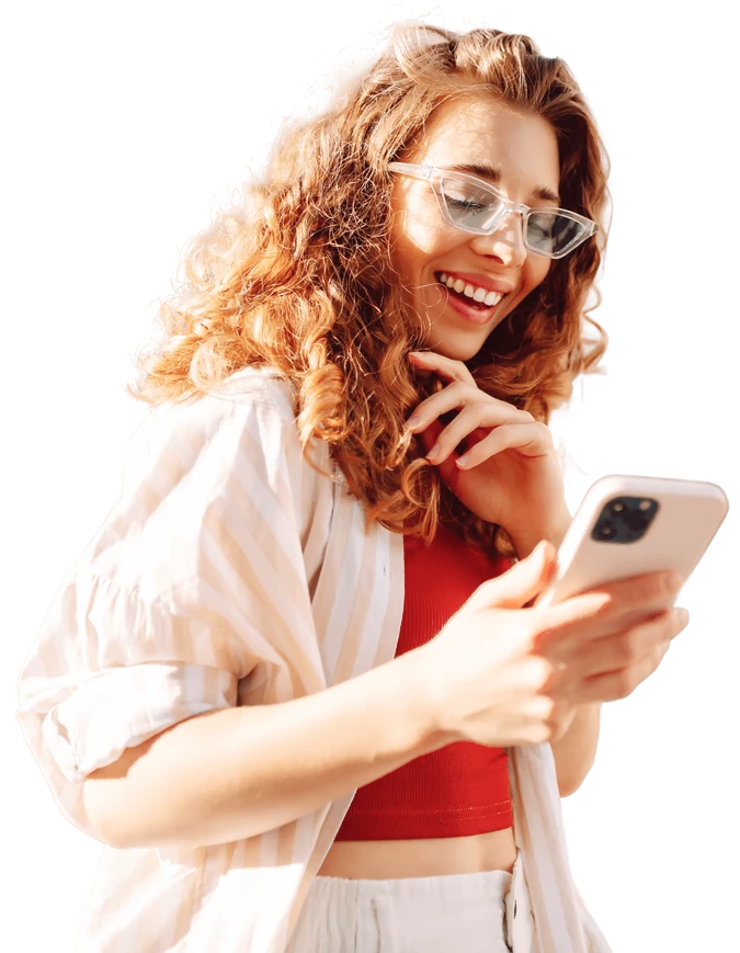 Smiling woman with curly hair looking at her phone